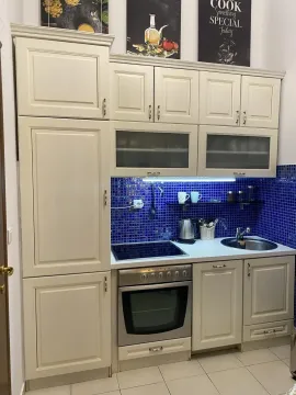 Kitchen with light cabinets and blue tiles. - image 6
