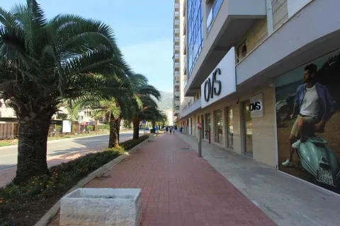 Exterior view of a building with commercial spaces and a sidewalk. - image 7