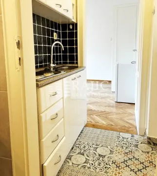 Small kitchen with white cabinets and decorative tiles. - image 7