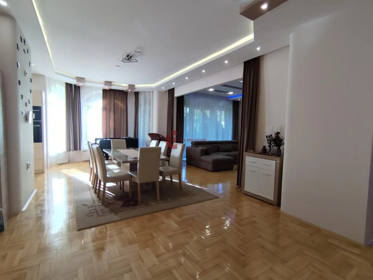 Spacious living room with dining area and parquet flooring.