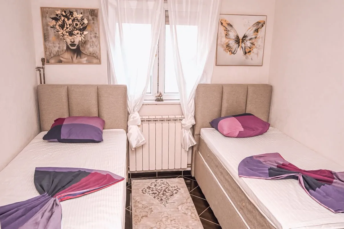 Decorated bedroom with two single beds and wall art.