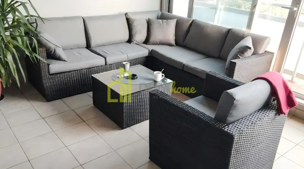 Furnished terrace with seating set and a small table.