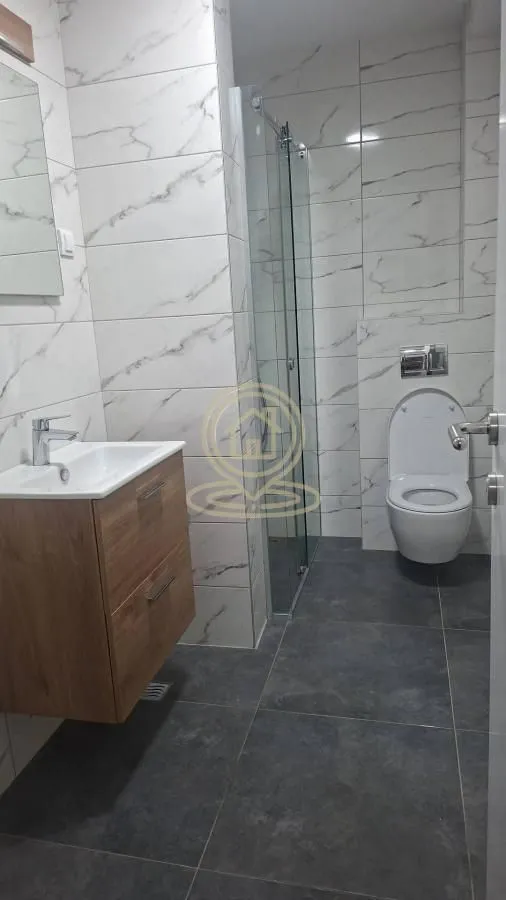 Savremeno opremljeno kupatilo sa tuš kabinom, umivaonikom i WC šoljom.