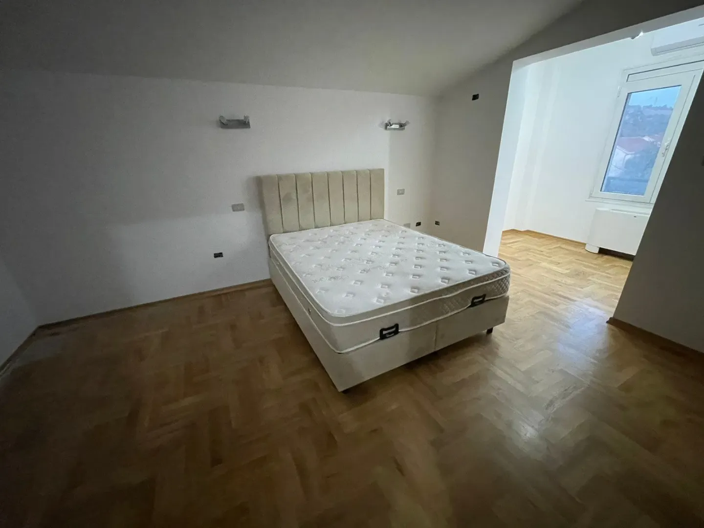 Bedroom with a double bed and parquet flooring.
