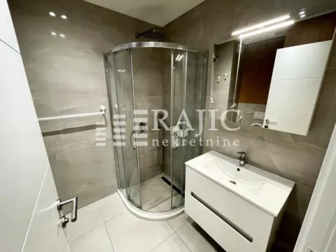 Modern bathroom with a shower cabin and a vanity sink. - image 6