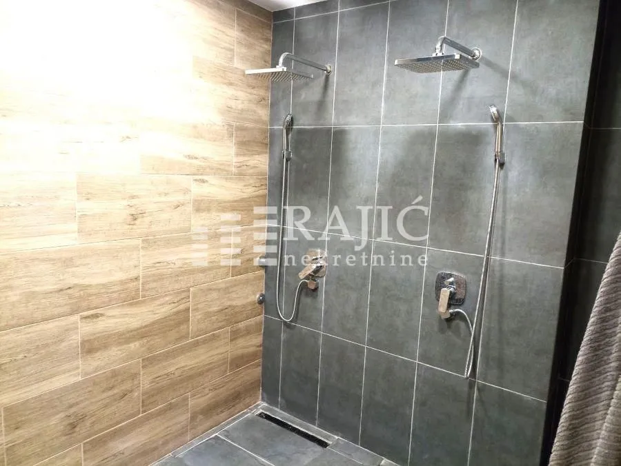 Modern bathroom with a shower cabin and double shower heads.