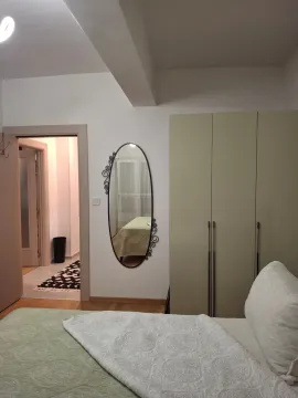 View of the bed, wardrobe, and mirror in the bedroom. - image 7