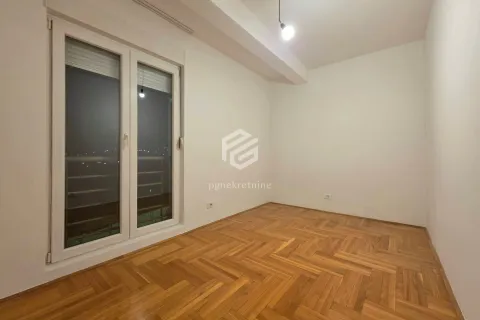Empty room with parquet flooring and a large window. - image 11