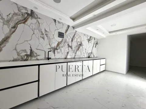 Modern kitchen with white units and a marble feature wall. - image 11