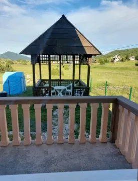 Pogled sa terase na drveni ljetnikovac i dvorište u prirodi. - image 15