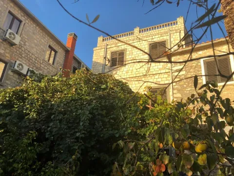 Eksterijer kuće sa kamenom fasadom i dvorištem sa zelenilom. - image 19