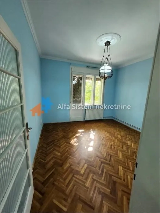 Empty room with parquet flooring and blue walls.