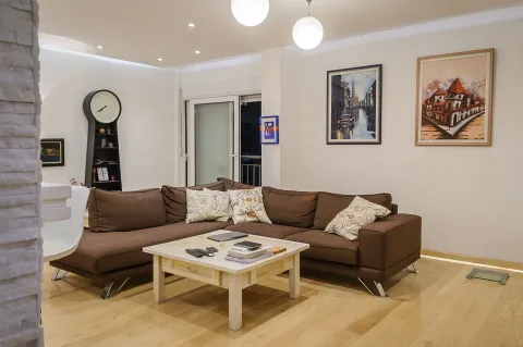 Living room with a corner sofa, coffee table and wall art. - image 3