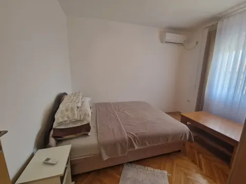 Furnished bedroom with a double bed, nightstand, and wooden flooring. - image 6
