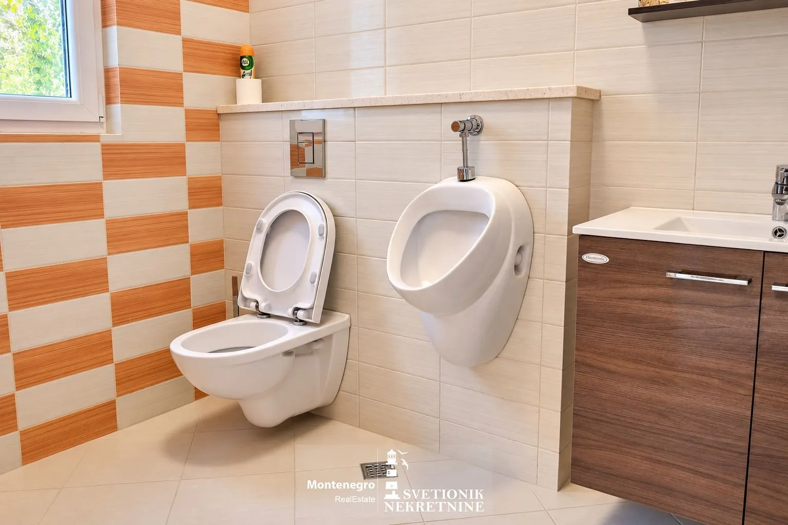Moderne kupatilo sa WC šoljom, pisoarom i umivaonikom.