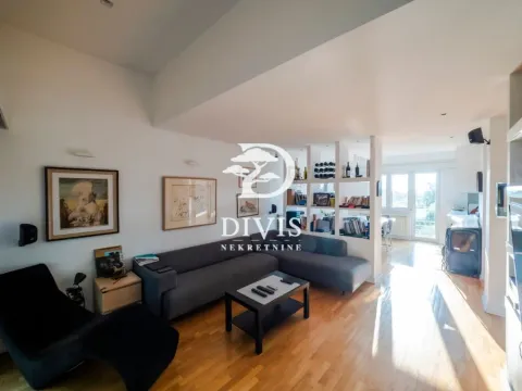 Living room with a sectional sofa, coffee table, and shelving units. - image 16