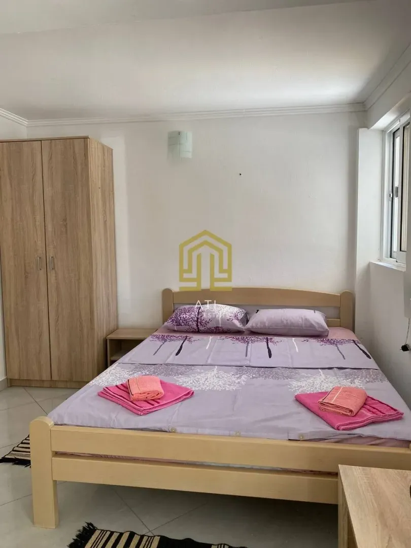 Furnished bedroom with a double bed and a wardrobe.