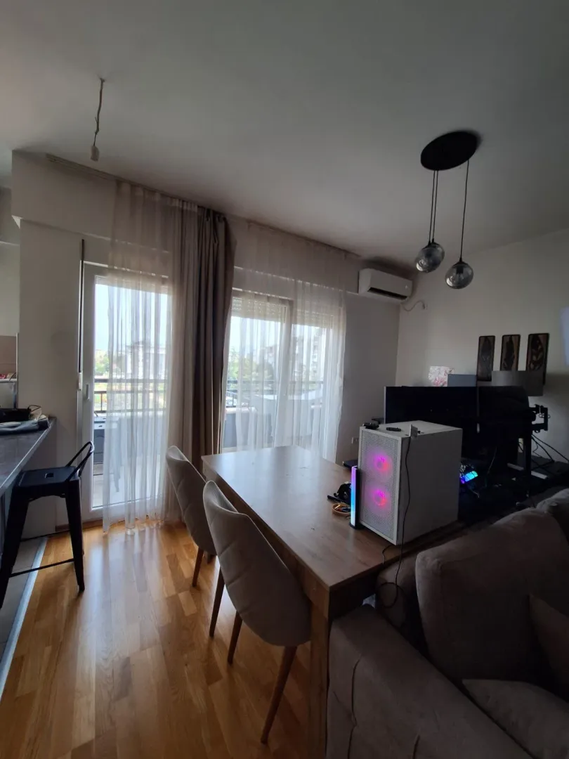 Dnevna soba sa trpezarijskim stolom i izlazom na terasu.