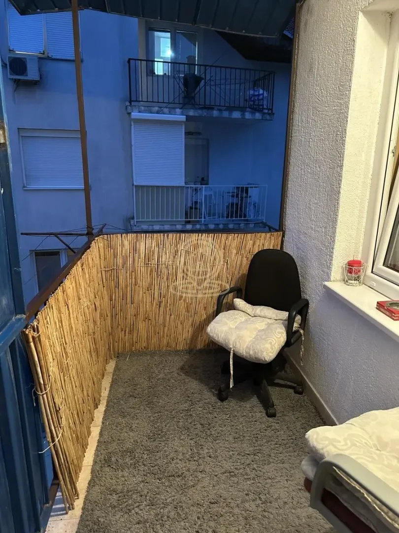 Natkriveni balkon sa stolicom i ogradom od trske.