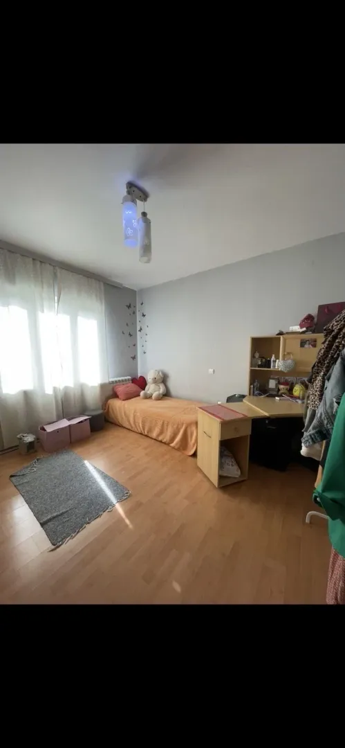 Svijetla dječija soba sa jednim krevetom i radnim stolom.