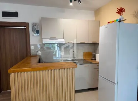 Manja kuhinja sa drvenim šankom i belim frižiderom. - image 3