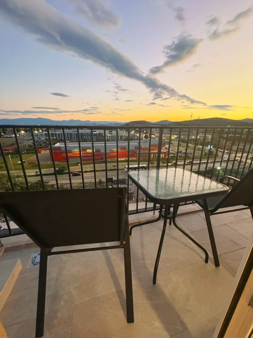 Furnished balcony with a table and chairs and a city view.