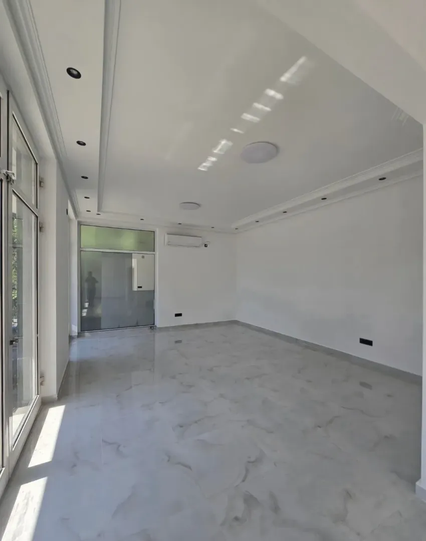 Empty bright room with tiled floor and white walls.