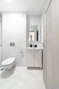 Moderne i svijetlo uređeno kupatilo sa bijelim mermernim pločicama. - image 3