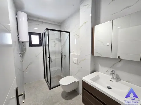 Modernly equipped bathroom with a shower cabin, washbasin, and toilet. - image 3