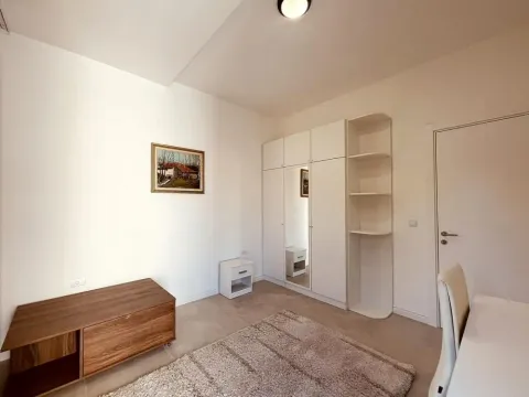 Svetla spavaća soba sa ugradnim plakarom, radnim stolom i tepihom. - image 13