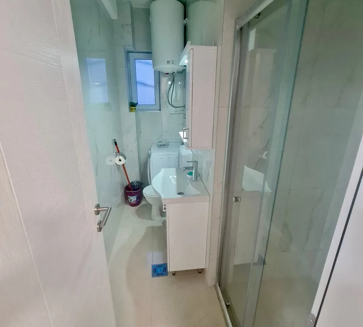 Smaller bathroom with a sink, shower cabin, and toilet.