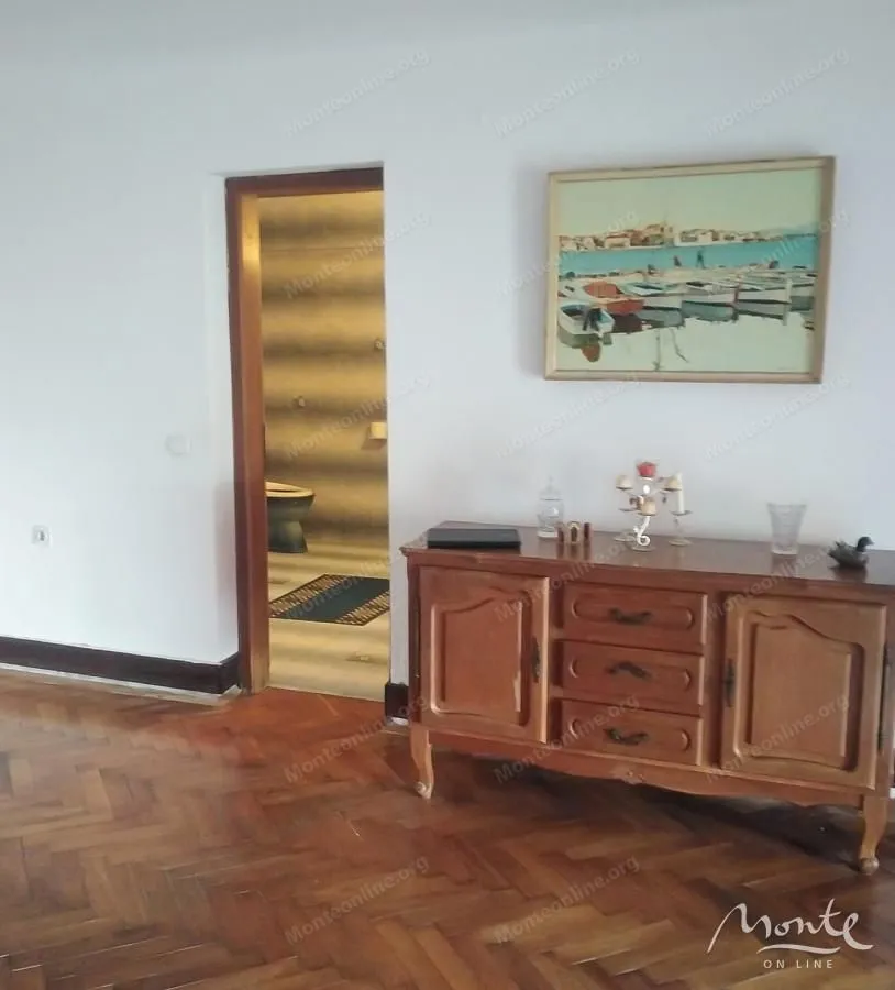 Living room with a wooden chest of drawers and a painting on the wall.