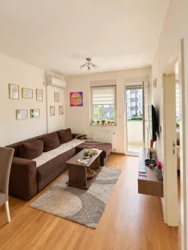 Dnevna soba sa braon garniturom, stočićem i izlazom na terasu. - image 3