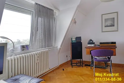 Dnevna soba sa kosim krovom, prozorom i drvenim podom. - image 9