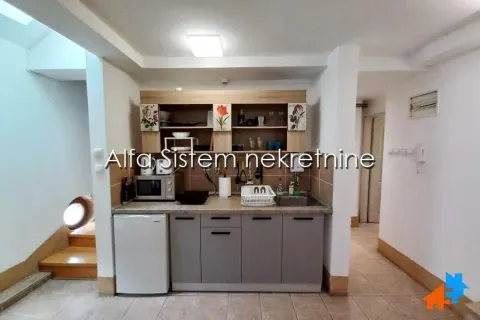 Small kitchen with grey cabinets and wooden wall units. - image 9