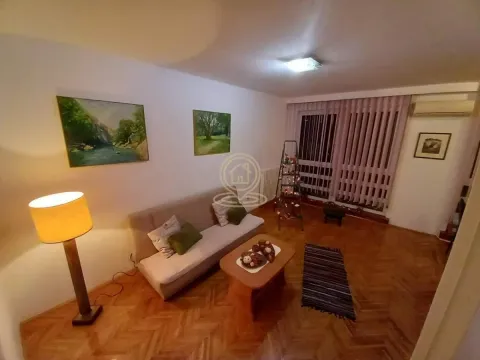 Living room with a sofa, coffee table and paintings on the wall. - image 6