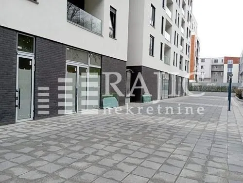 Exterior of a modern residential building with a paved courtyard.