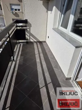 Pogled na prostrani balkon sa tamnim pločicama i metalnom ogradom. - image 10