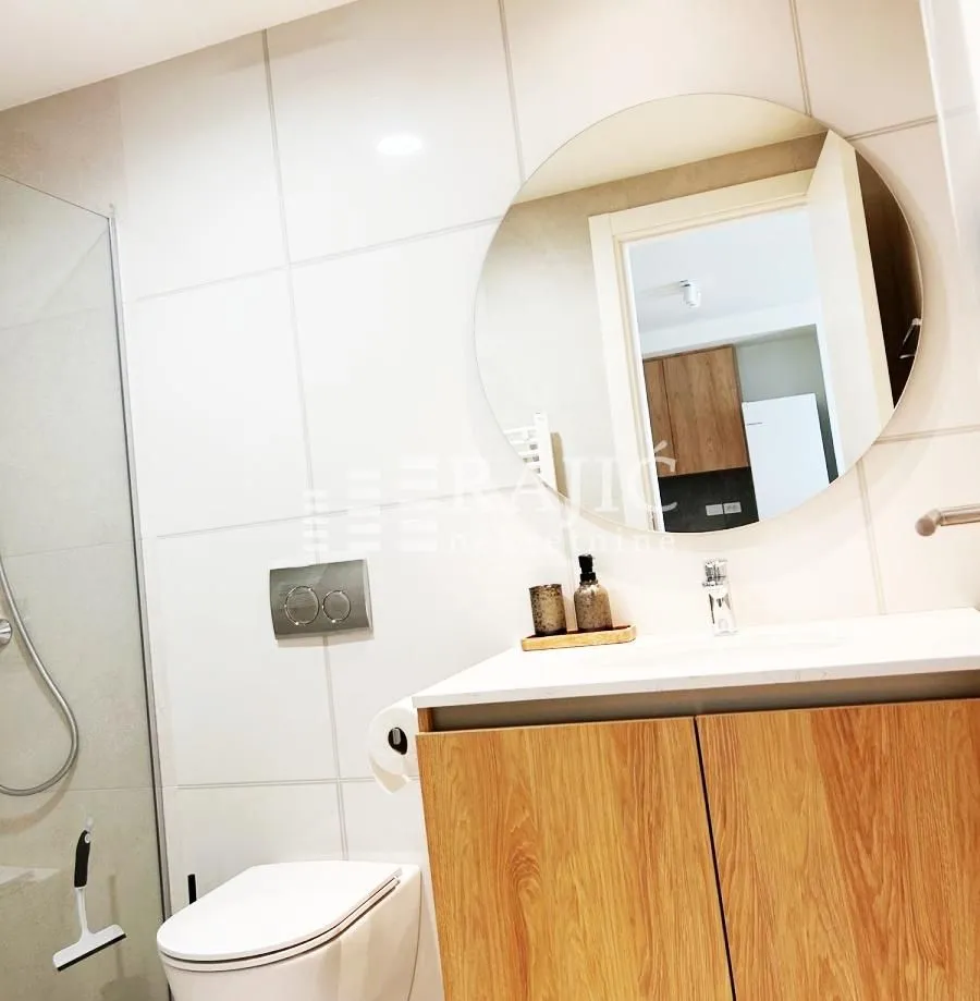 Modern bathroom equipped with a washbasin, toilet, and walk-in shower.