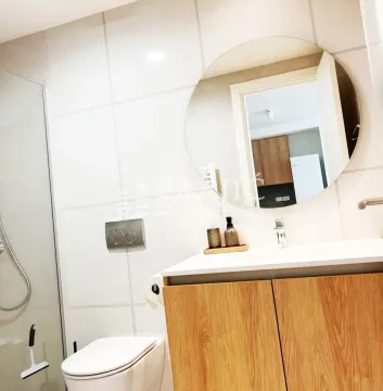 Modern bathroom equipped with a washbasin, toilet, and walk-in shower. - image 7