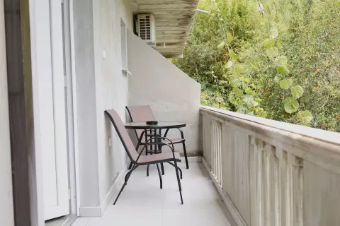 Manji namješteni balkon sa stolom i dvije stolice i pogledom na zelenilo. - image 10