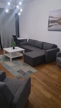 Udobna dnevna soba sa ugaonom garniturom, stočićem i drvenim podom. - image 2