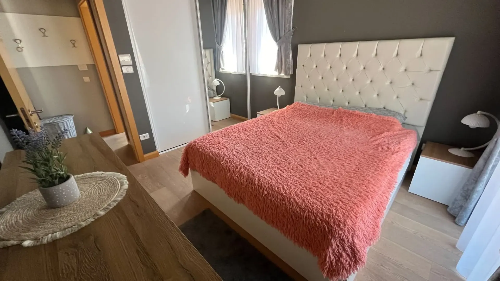 Furnished bedroom with a double bed, wardrobe, and window.