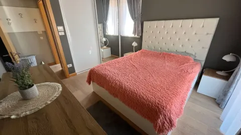 Furnished bedroom with a double bed, wardrobe, and window. - image 9