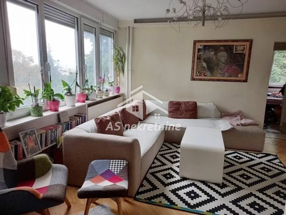 Living room with a sectional sofa, coffee table, and large windows.