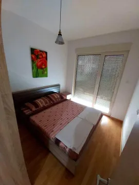A simple bedroom with a double bed and a painting on the wall. - image 10