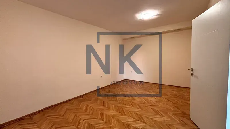 Empty room with parquet flooring and white walls.