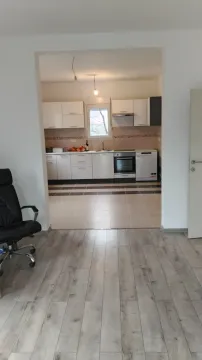 View of a kitchen with white cabinets from an adjacent room. - image 27