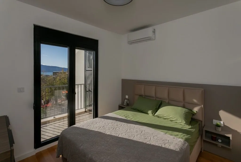 Spavaća soba sa bračnim krevetom i izlazom na terasu.