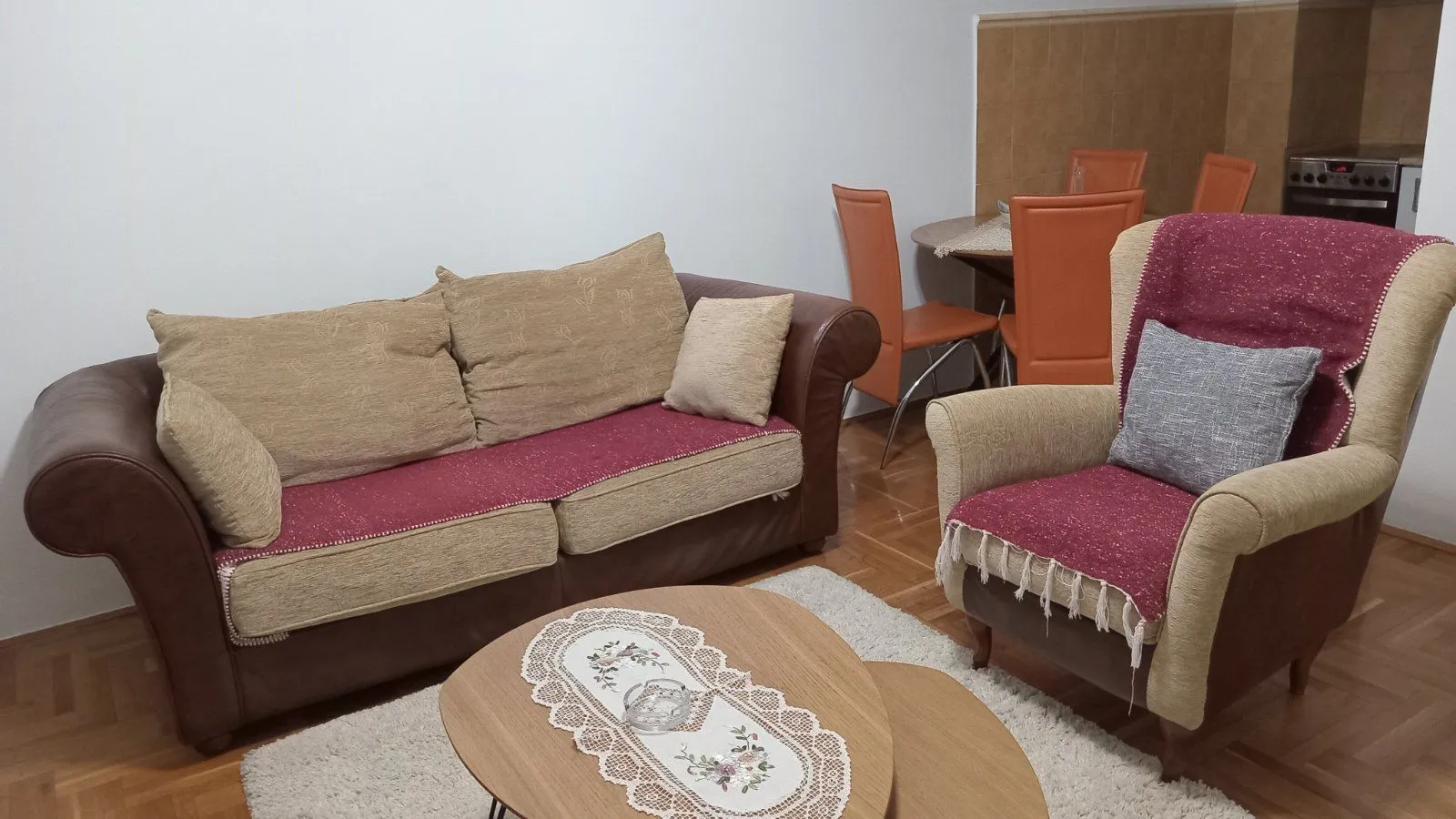 Living room with a seating set, coffee table, and a dining area in the background.